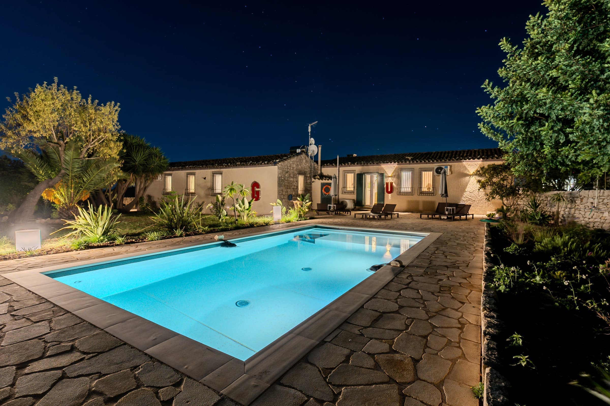 Swimming pool illuminated at night with tropical ambiance