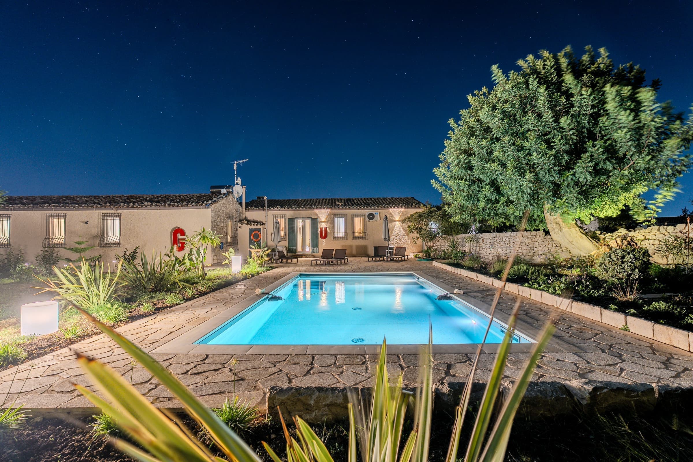 Pool at night reflecting the villa's warm lights